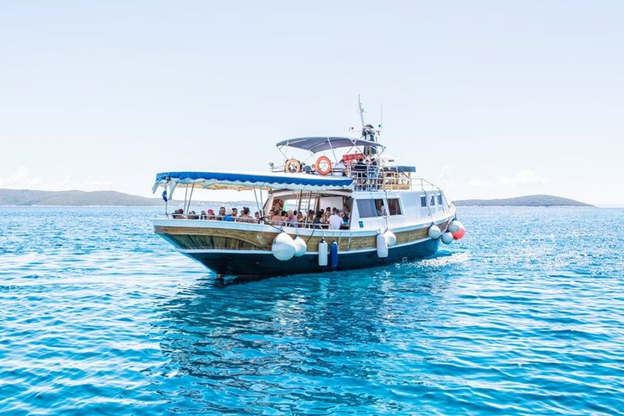 Bateau de croisière dans les eaux cristallines de la lagune bleue près de Trogir, Croatie.