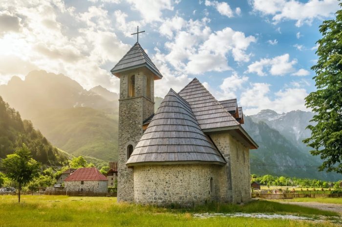 Église pittoresque de Theth entourée des montagnes majestueuses des Alpes albanaises.