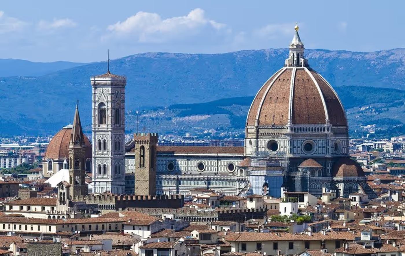 Vue panoramique de la cathédrale Santa Maria del Fiore à Florence avec les montagnes en arrière-plan.