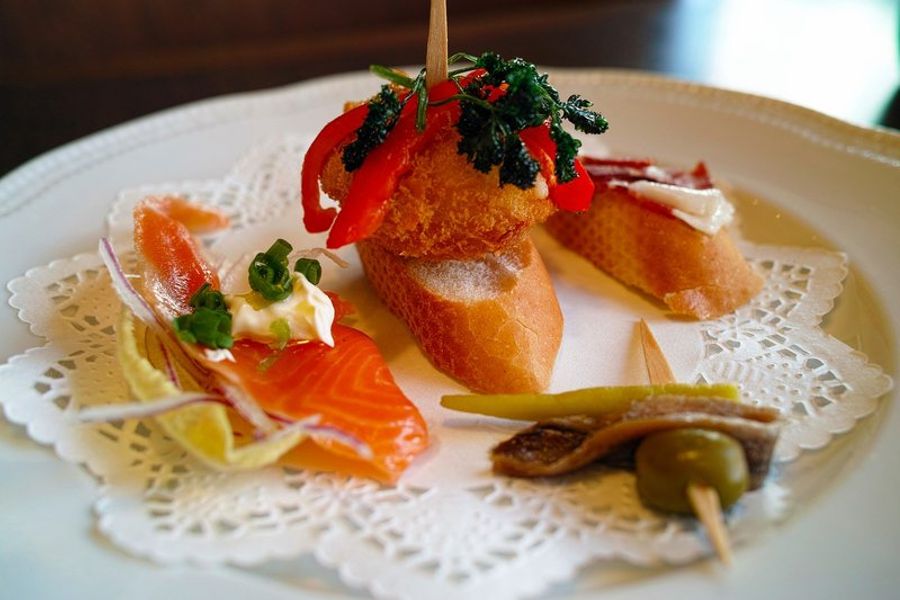 Assiette de pintxos variés avec des garnitures de poisson et de légumes.