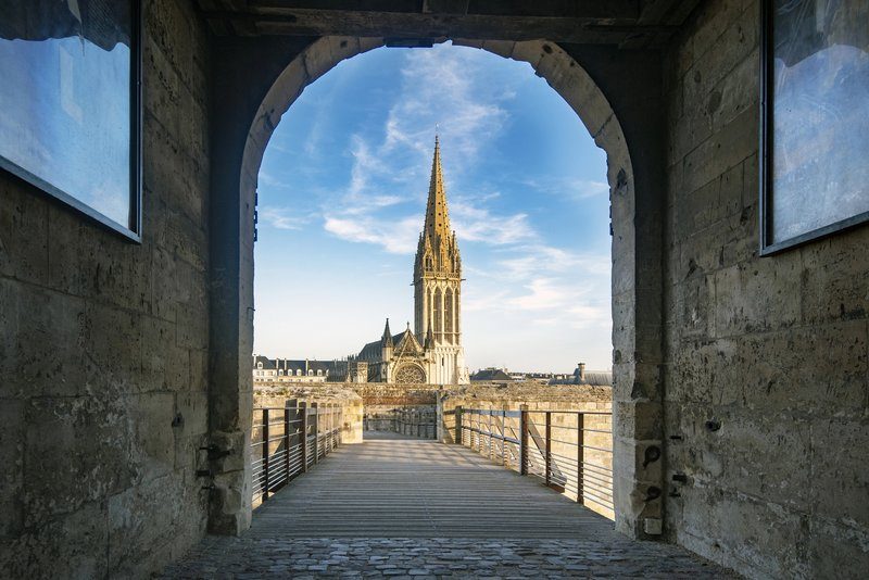 Vue sur la cathédrale de Caen depuis une arcade médiévale.