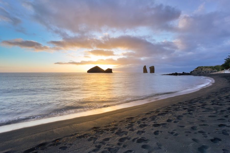 Coucher de soleil sur la plage de sable noir de Mosteiros à São Miguel, Açores.