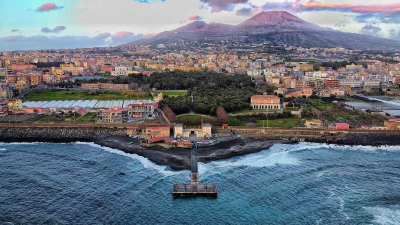 Vue aérienne de la ville de Naples, Italie, avec le mont Vésuve en arrière-plan et la mer au premier plan.