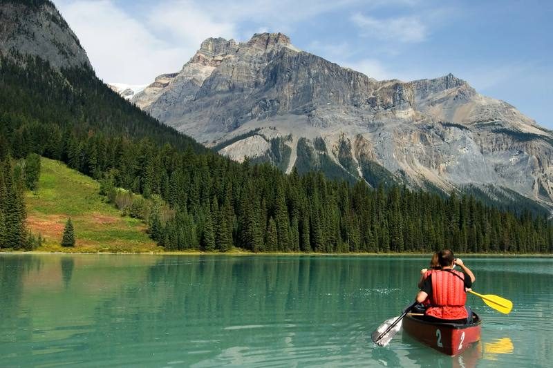 Canoë sur un lac turquoise au pied des Rocheuses canadiennes dans le parc national de Banff — activité de plein air sur mesure