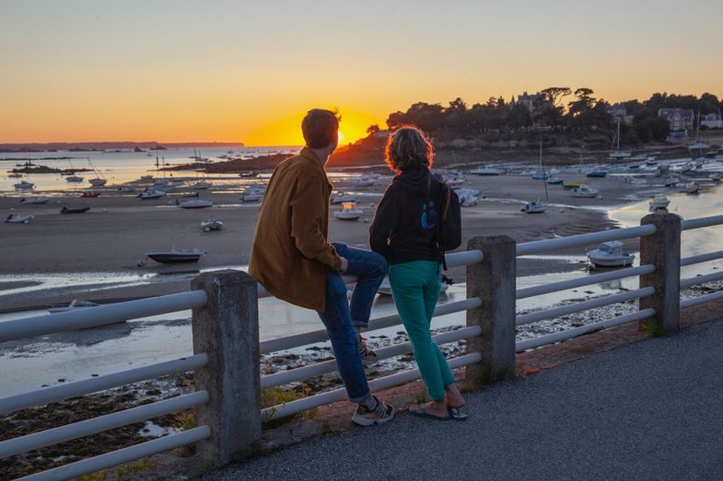 Couple admirant le coucher de soleil sur la côte bretonne lors d’un week-end romantique à Saint-Briac-sur-Mer.