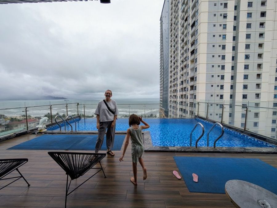 Vue sur la piscine rooftop du Halina Hotel avec la mer et les immeubles en arrière-plan