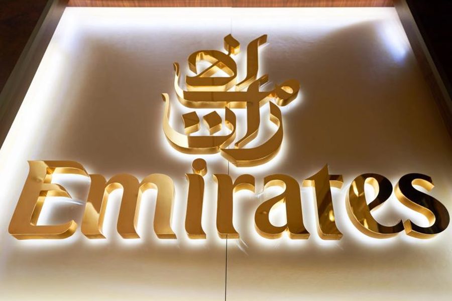 Logo Emirates en lettres dorées avec un design éclairé, présenté dans un style moderne et élégant.