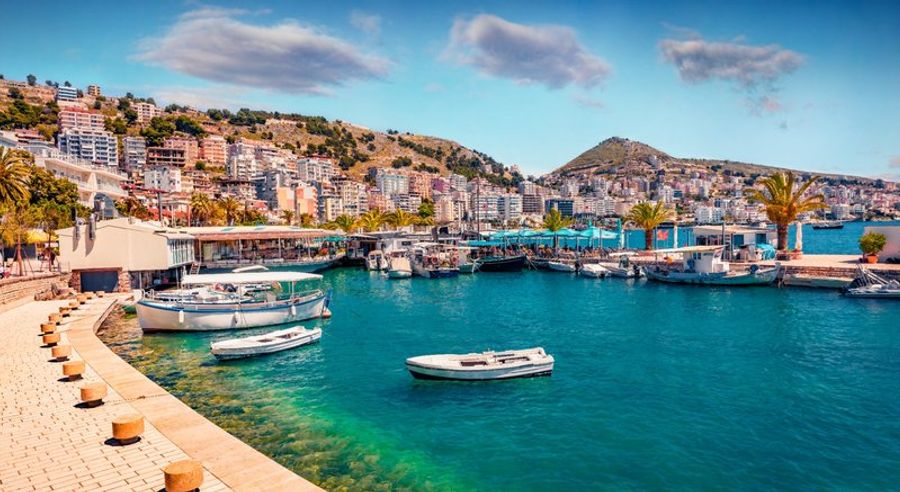 Port de Saranda avec ses bateaux et bâtiments colorés en bord de mer.