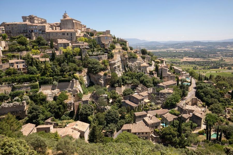 Vue panoramique sur le village perché de Gordes et ses environs verdoyants.