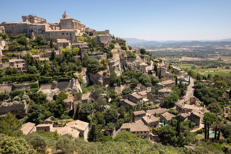 Vue panoramique sur le village perché de Gordes et ses environs verdoyants.
