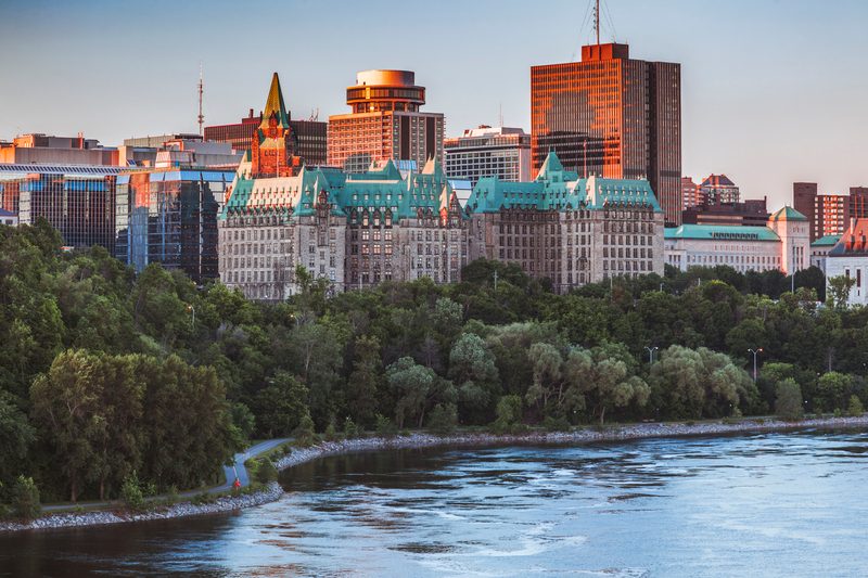 Vue du Fairmont Château Laurier à Ottawa, entouré de verdure.