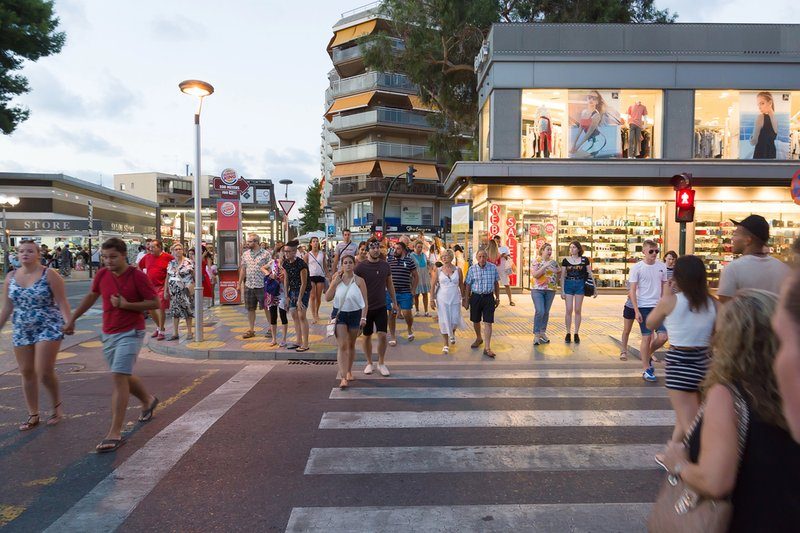 Groupe de personnes traversant une rue animée du centre commercial de Salou.