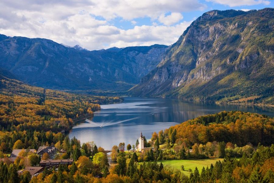 Vue panoramique du lac de Bohinj encadré par les sommets des Alpes juliennes en Slovénie, aux eaux limpides et turquoise