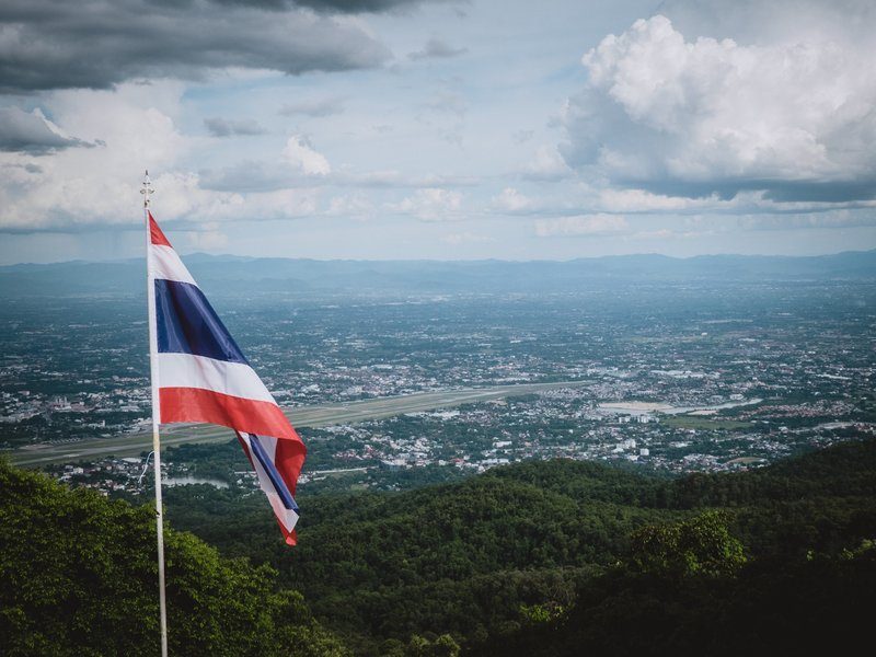 Vue panoramique de Doi Suthep avec un drapeau thaïlandais au premier plan.