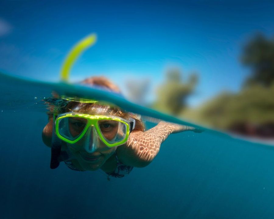 Personne en plongée avec un masque de snorkeling dans les eaux claires de Puerto Viejo.