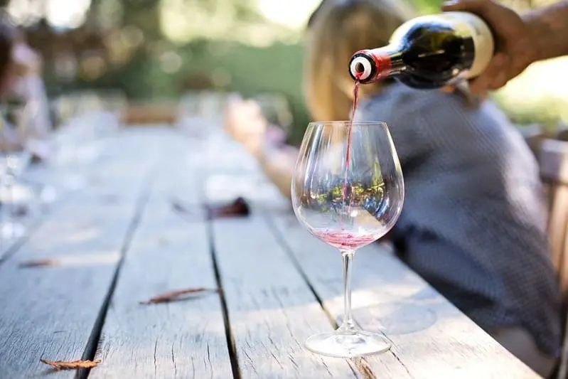 Une personne qui se sert du vin