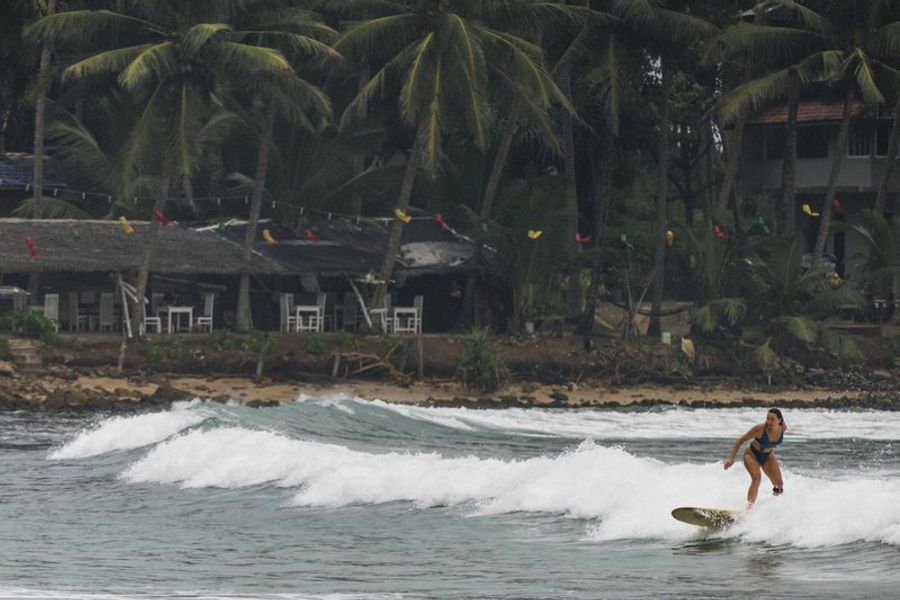 Une surfeuse glisse sur une vague à Hiriketiya, un spot réputé pour le surf au Sri Lanka.