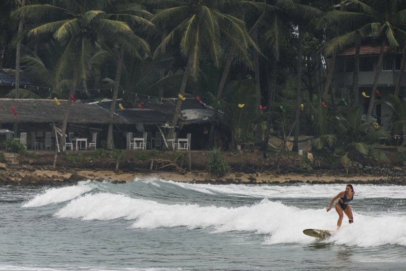Une surfeuse glisse sur une vague à Hiriketiya, un spot réputé pour le surf au Sri Lanka.