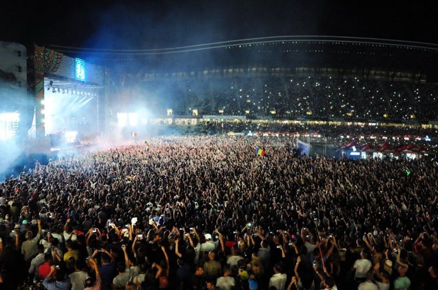 Foule réunie au festival de musique Untold à Cluj, de nuit.