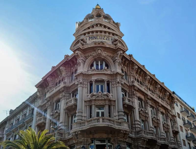 Façade élégante et détaillée du Palazzo Mincuzzi à Bari, sous un ciel bleu clair.