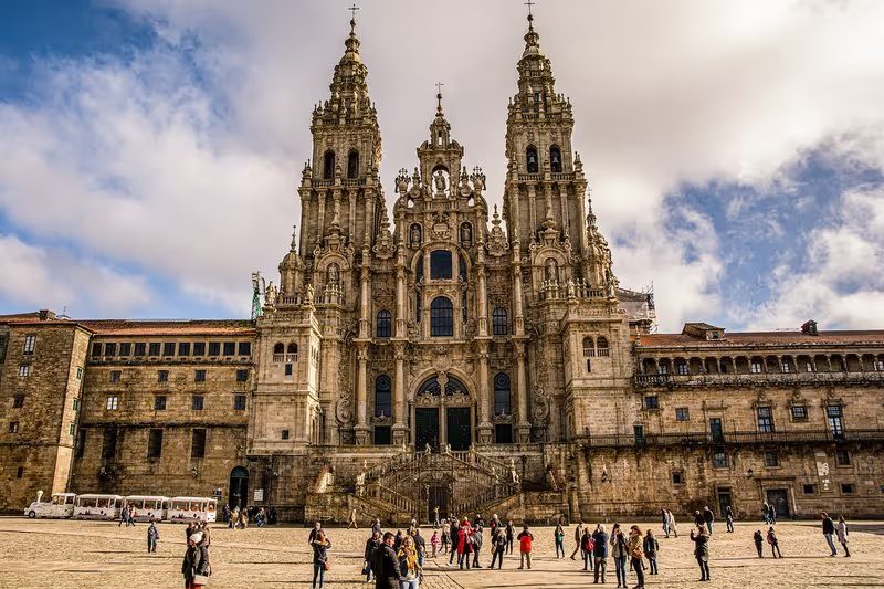 La façade de la cathédrale de Saint-Jacques-de-Compostelle sous un ciel partiellement nuageux.
