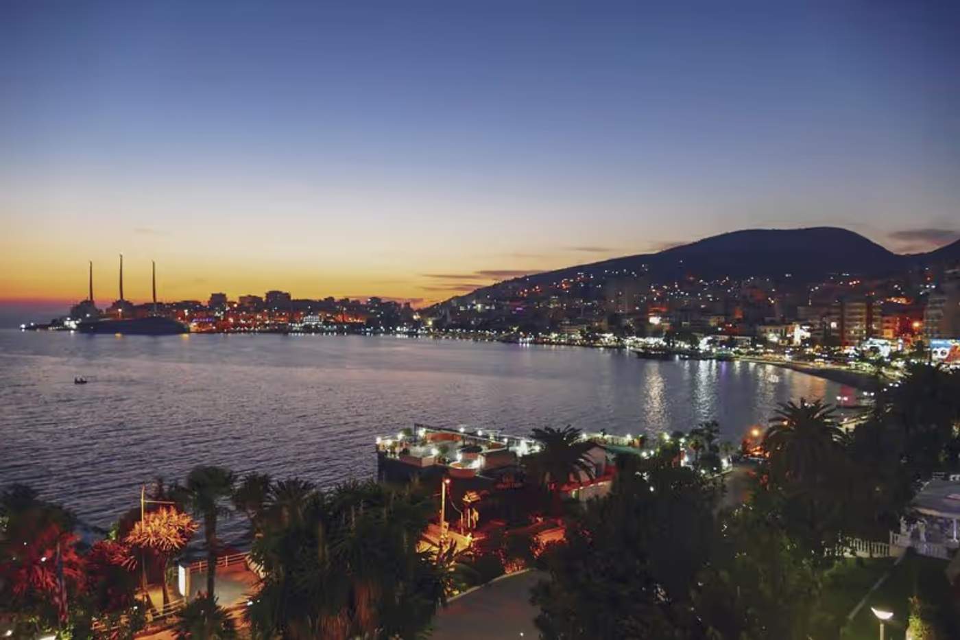 Vue nocturne sur Saranda, avec la ville illuminée le long de la côte albanaise.
