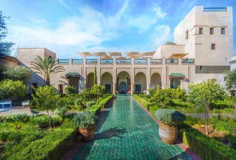 Riad traditionnel de Marrakech avec jardin luxuriant et architecture marocaine typique