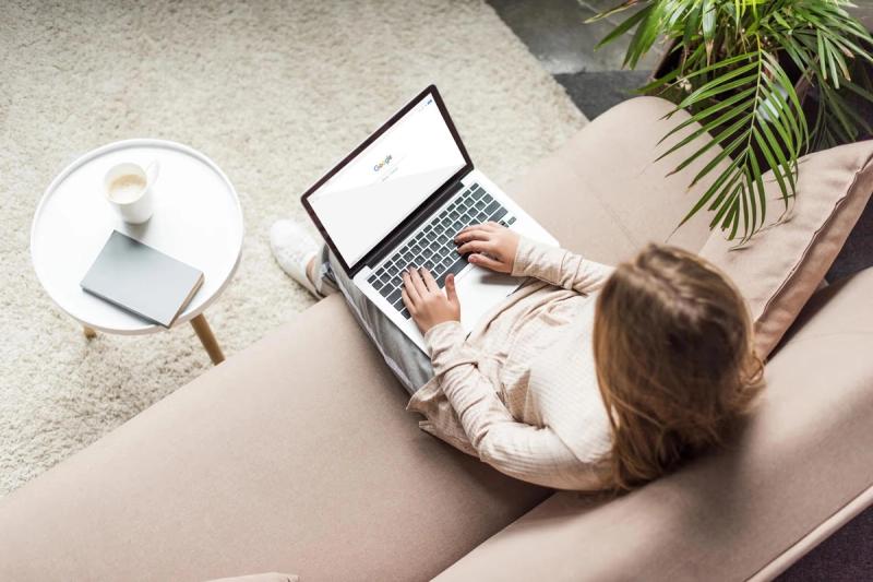 Personne travaillant sur un ordinateur portable avec Google sur l'écran, dans un cadre relaxant à la maison.