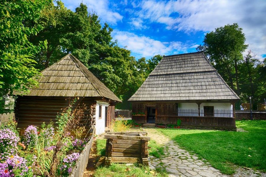 Maisons traditionnelles roumaines en bois au Musée du Village de Bucarest, recréant le mode de vie rural dans un cadre naturel.