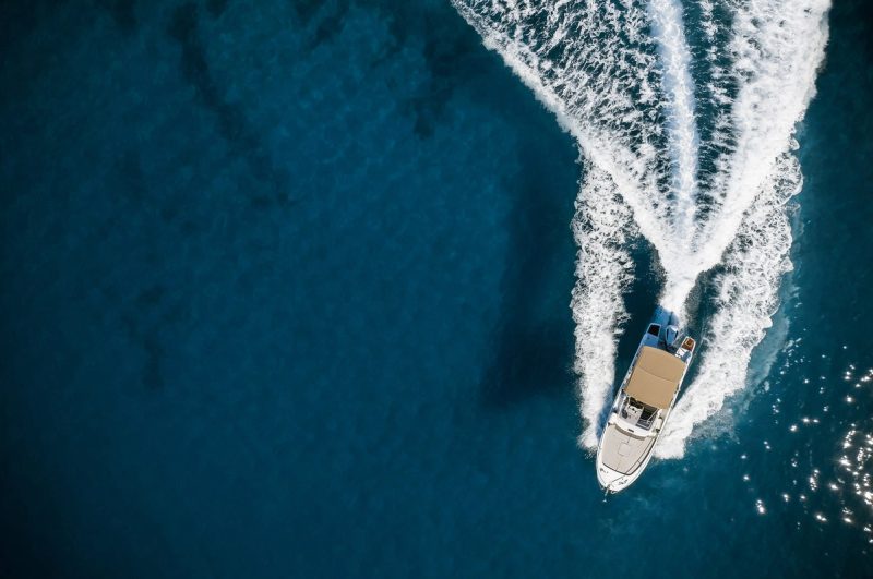 Vue aérienne d'un bateau de croisière naviguant sur une mer bleue avec un sillage en forme de V