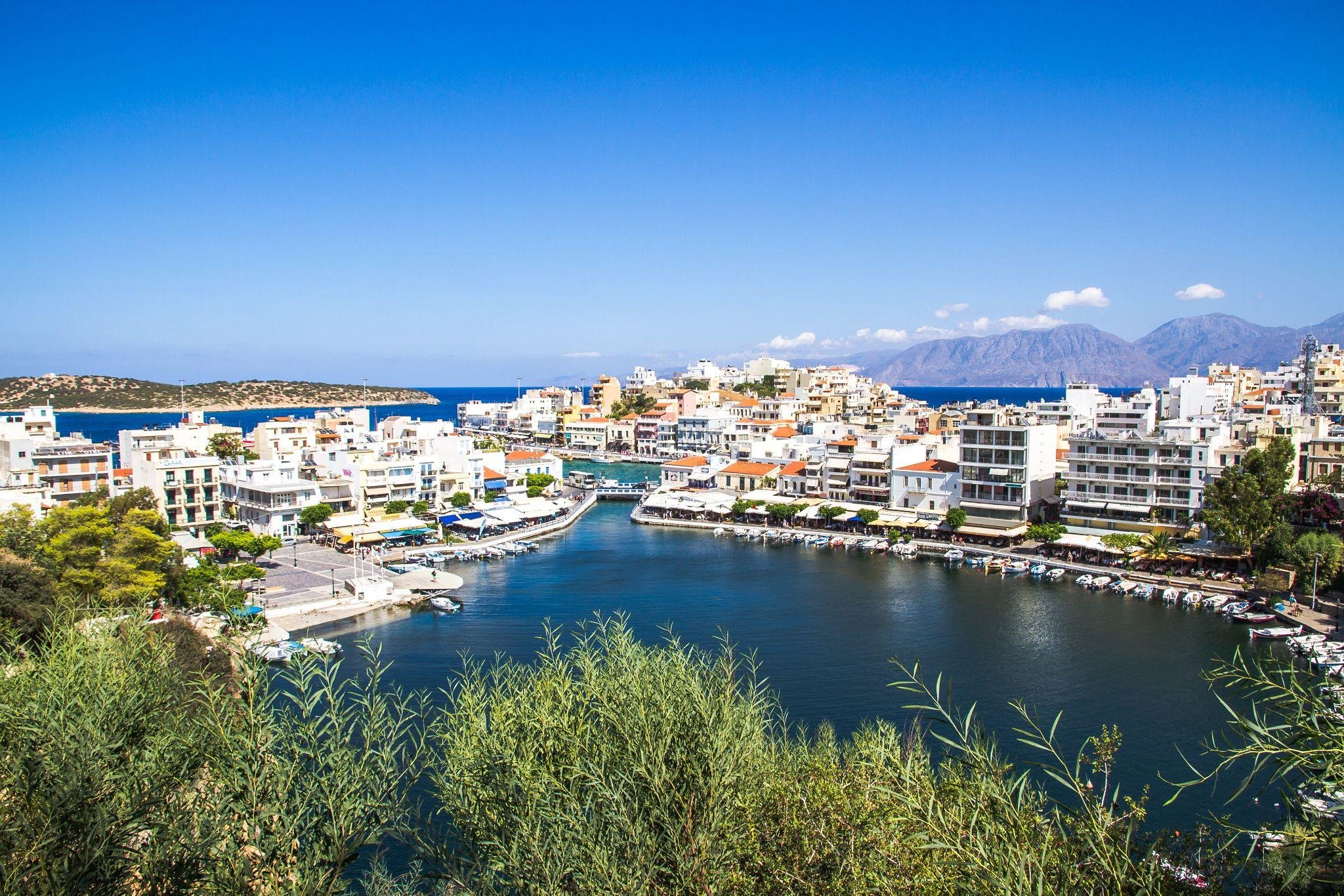 Vue aérienne d'une ville en Gèce avec un port et des montagnes en fond