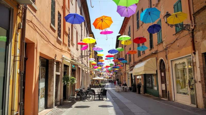  Rue colorée avec des parapluies suspendus à Ferrara, Italie.