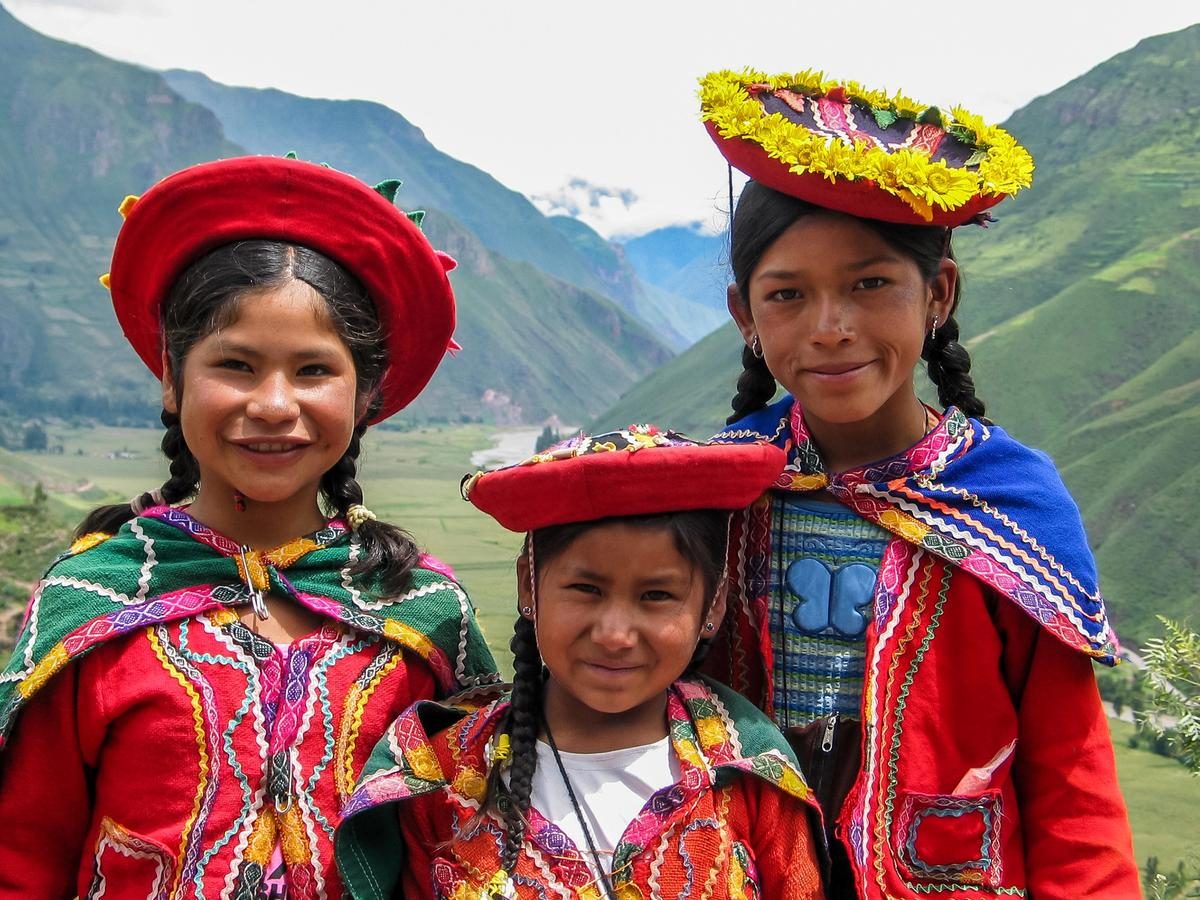 Trois enfants en habits traditionnels andins dans la vallée sacrée du Pérou