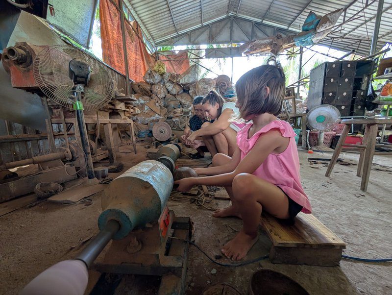 Atelier de fabrication de bols artisanaux en noix de coco, avec Anna en pleine activité.