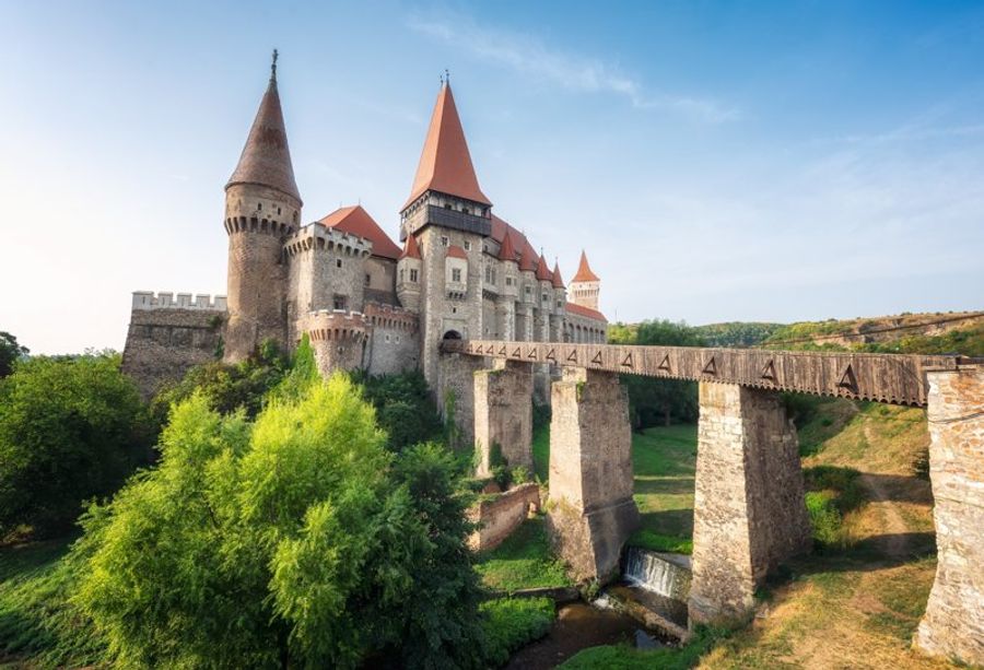 Château de Corvin en Roumanie, imposant château médiéval avec tours et pont-levis.
