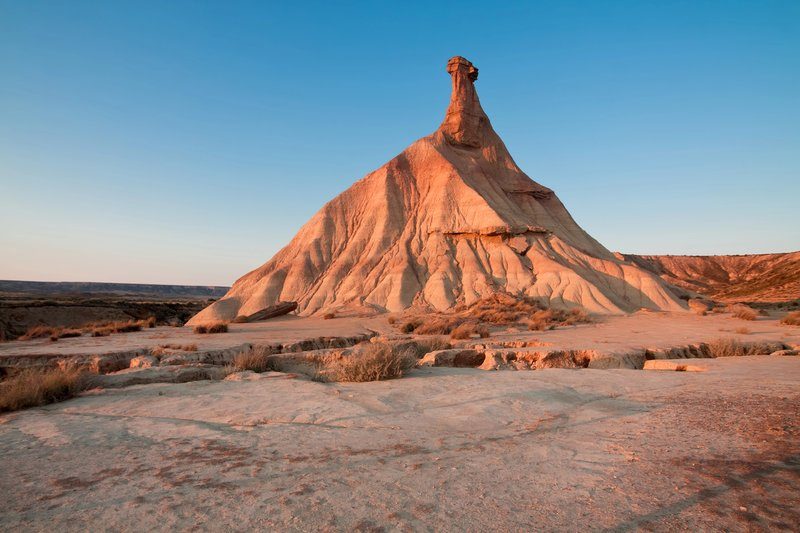 Formation rocheuse emblématique en forme de cheminée de fée dans le désert des Bardenas Reales au coucher du soleil.