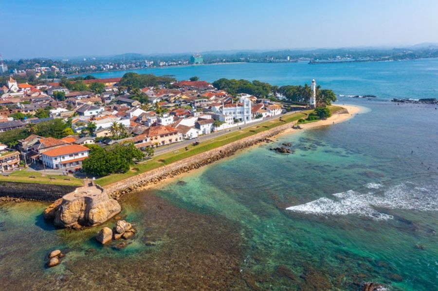 Vue aérienne du Fort de Galle au Sri Lanka, avec ses bâtiments coloniaux aux toits rouges, son phare emblématique et ses remparts bordés par l