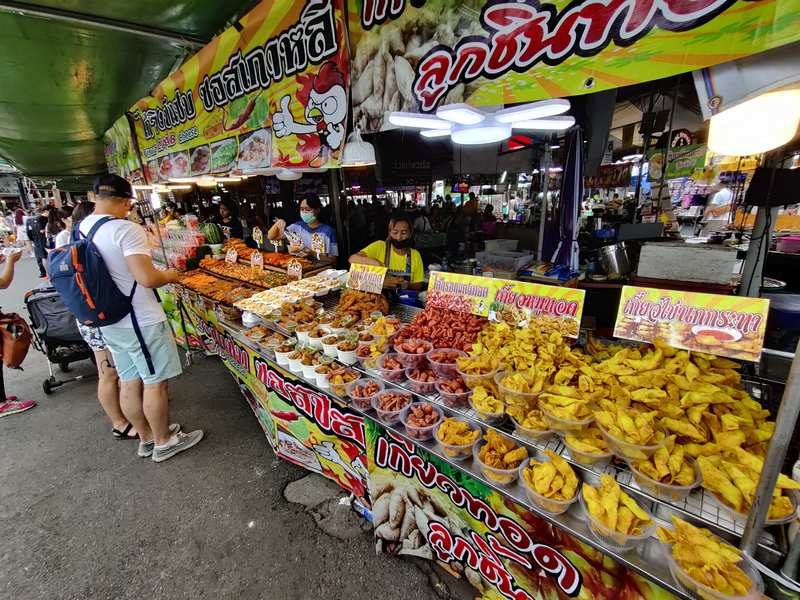 Stands animés du marché Chatuchak à Bangkok, regorgeant de nourriture.
