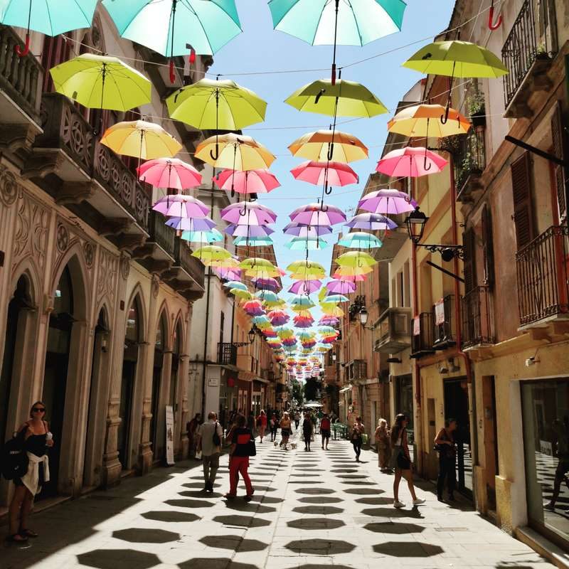 Rue décorée avec des parapluies suspendus.