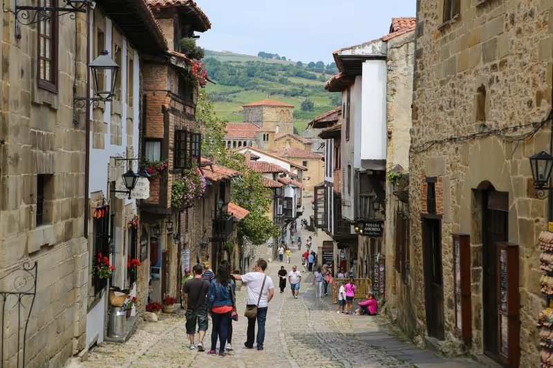 Rue pavée dans le village historique de Santillana del Mar avec des maisons en pierre.