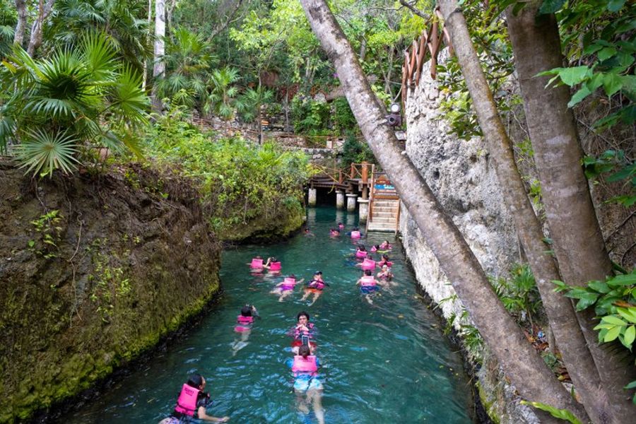Touristes nageant dans une rivière naturelle à Xcaret, Tulum.