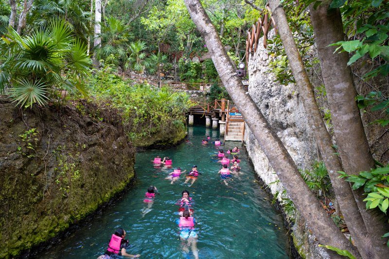 Touristes nageant dans une rivière naturelle à Xcaret, Tulum.