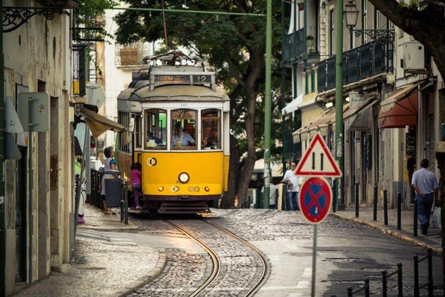 Tramway jaune traversant les rues étroites du quartier d