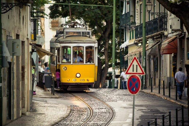Tramway jaune traversant les rues étroites du quartier d