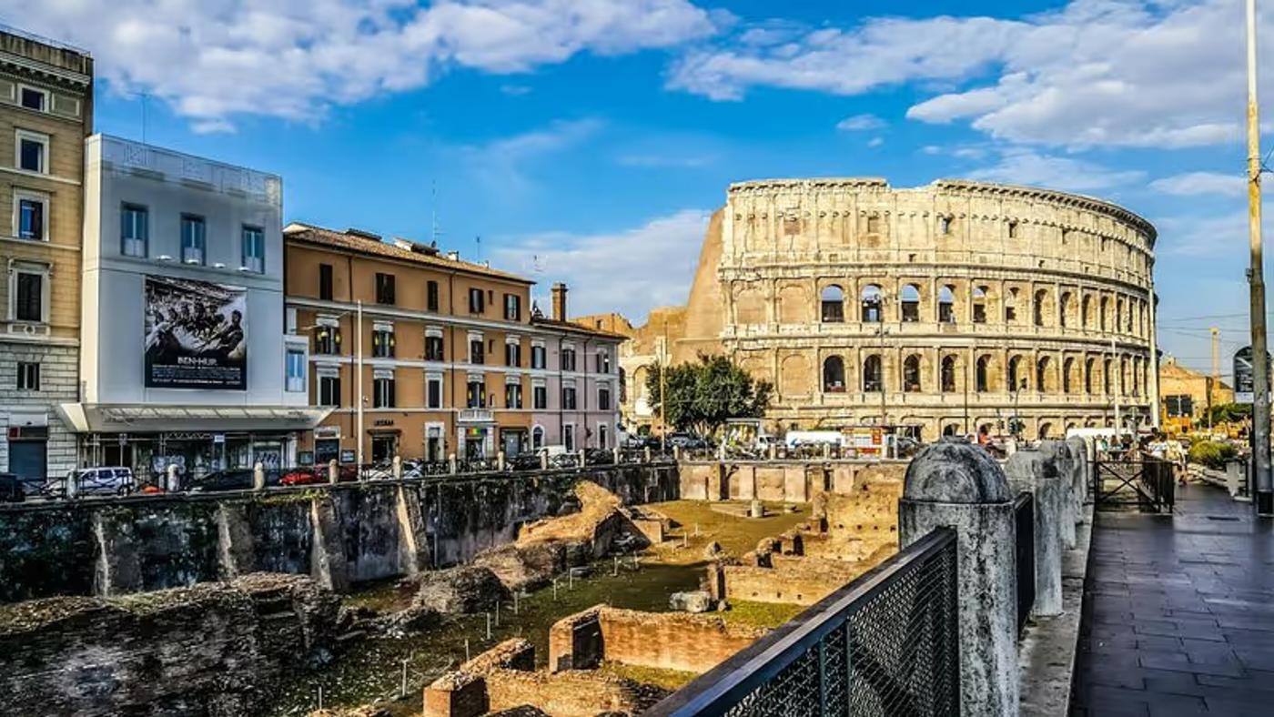 Vue du Colisée à Rome avec des bâtiments modernes au premier plan.