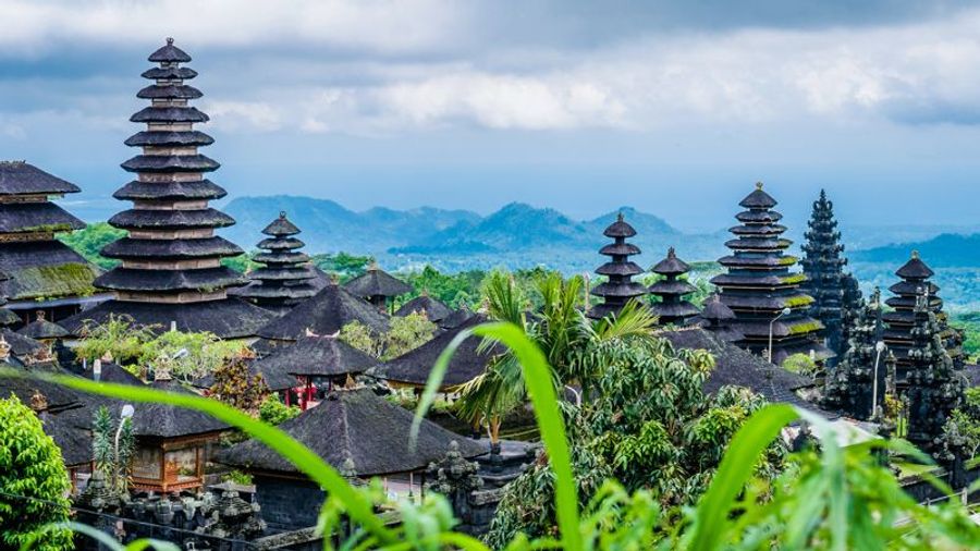 Vue panoramique sur le temple de Besakih à Sidemen, entouré de végétation luxuriante et de montagnes.