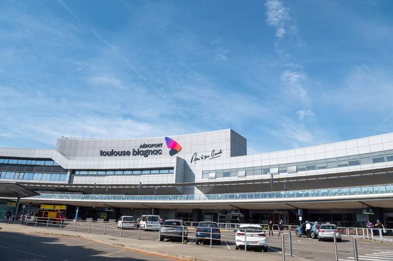 Façade principale de l’aéroport Toulouse Blagnac, zone départ sous ciel bleu