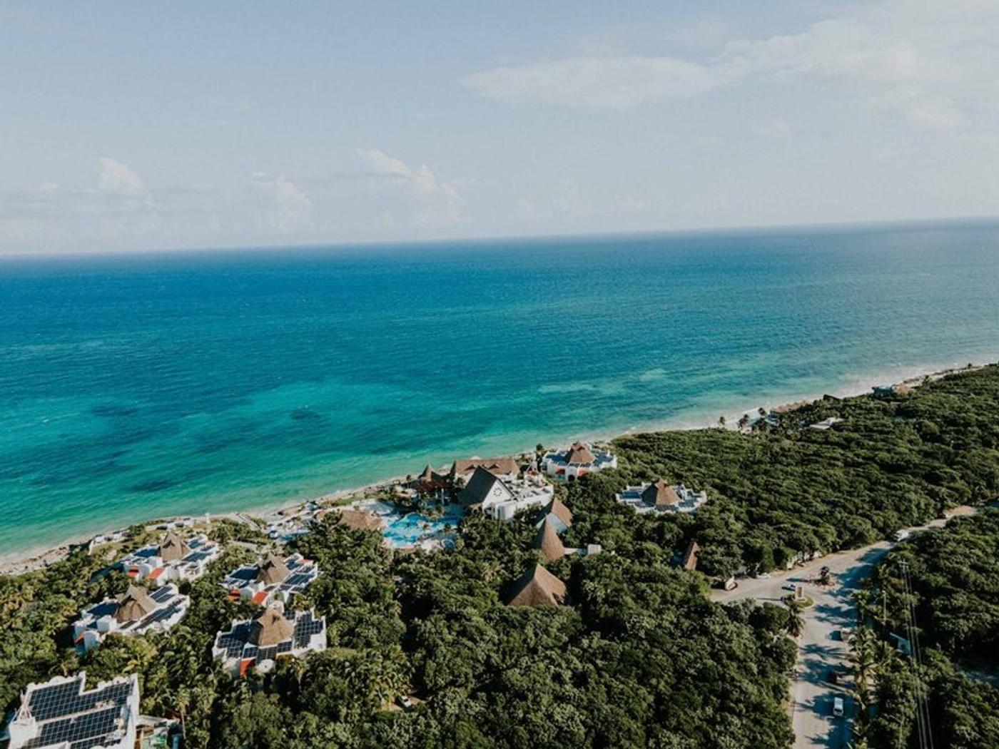 Vue aérienne de Tulum et la la mer des Caraïbes, entourées de végétation tropicale.