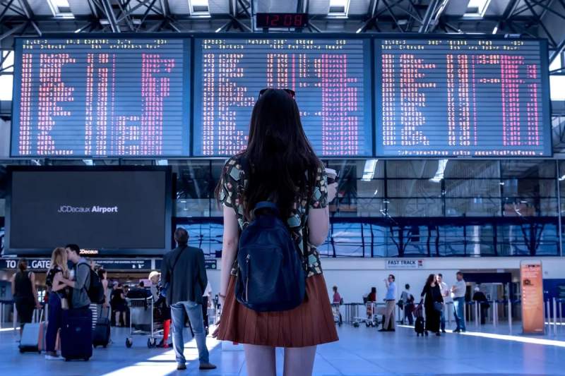 Une femme à l'aéroport regardant les horaires de vols