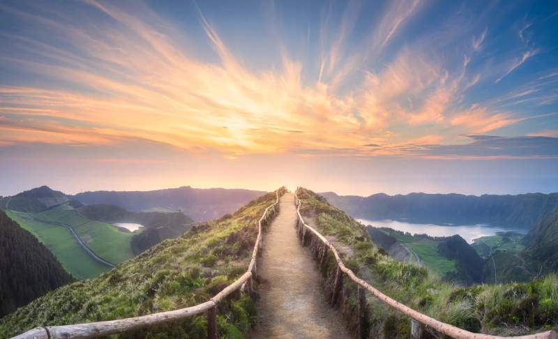 Sentier de randonnée menant à un point de vue surplombant les paysages verdoyants et les lacs de São Miguel, Açores, au coucher du soleil.